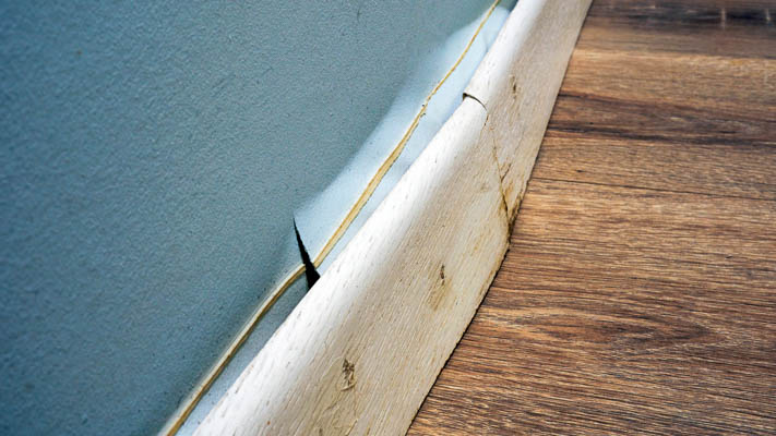 Stained and bulging baseboard caused by leak