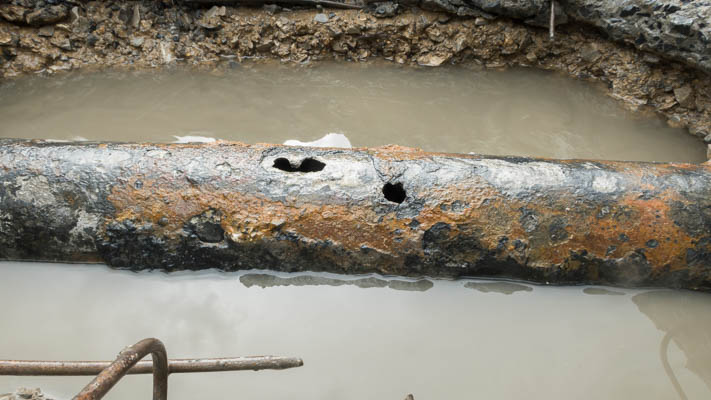 Rusty pipe leaking under a slab